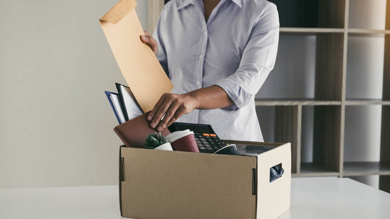 employee packing up all of their belongings into a cardboard box after being fired