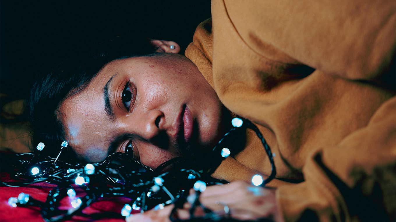 unhappy girl lying on floor with lights