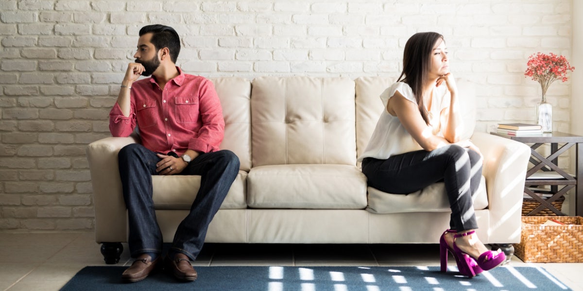 Why We End Things Before They Even Begin couple sitting on opposite ends of the couch