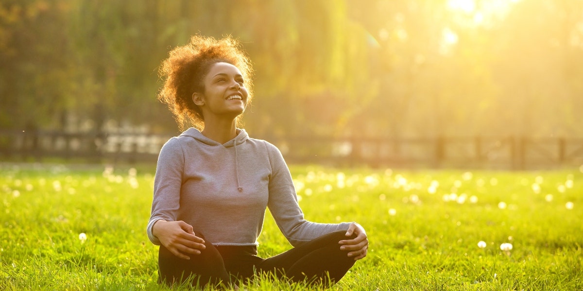 energy clearing meditation woman meditating on the grass