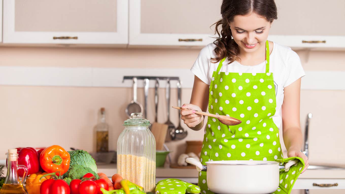 woman cooking at stove with smile