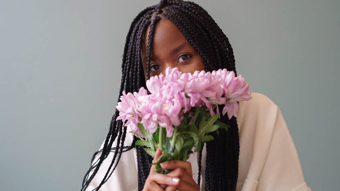 woman with braids holding flowers