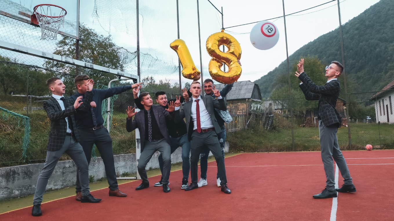 a group of boys standing on a basketball court