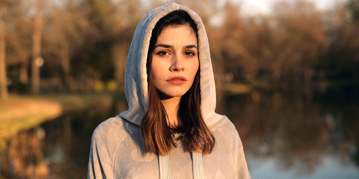 woman in gray hoodie looking at camera