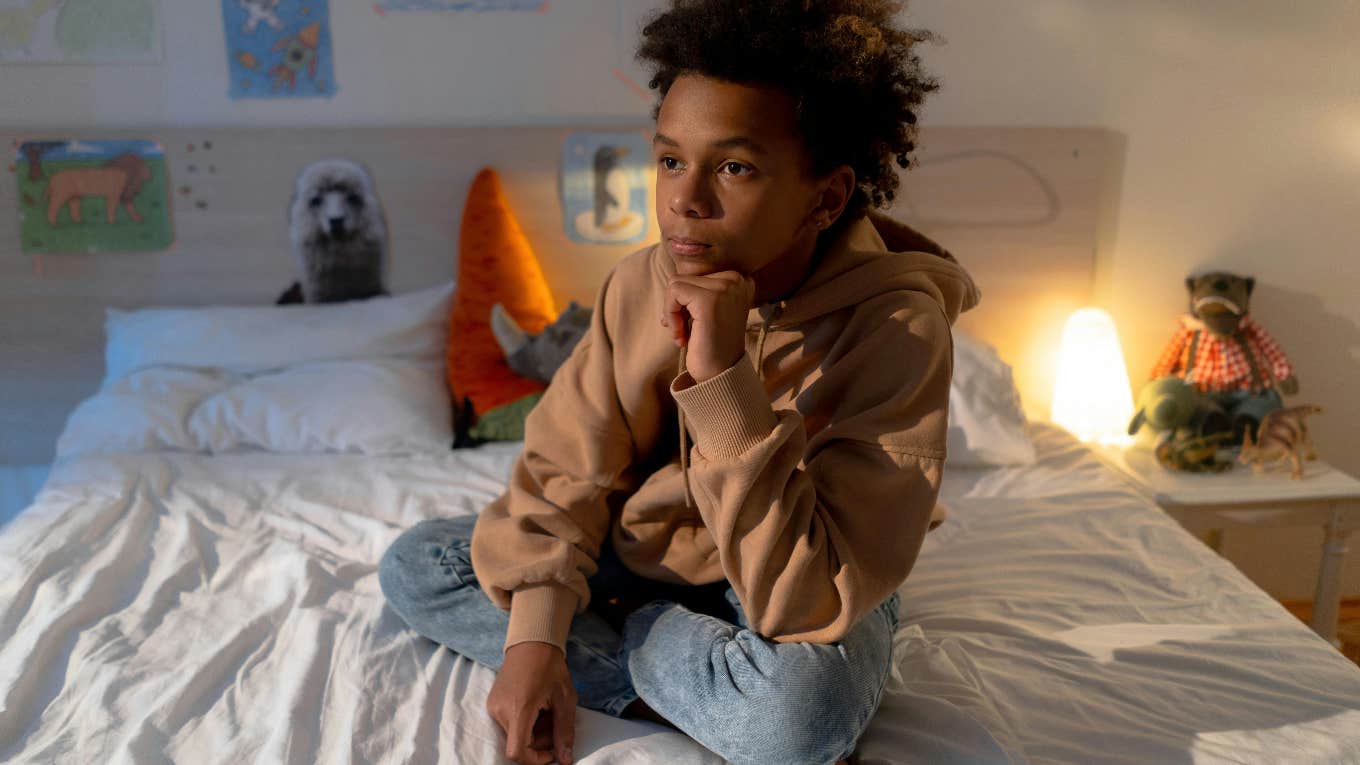 boy sitting on his bed alone