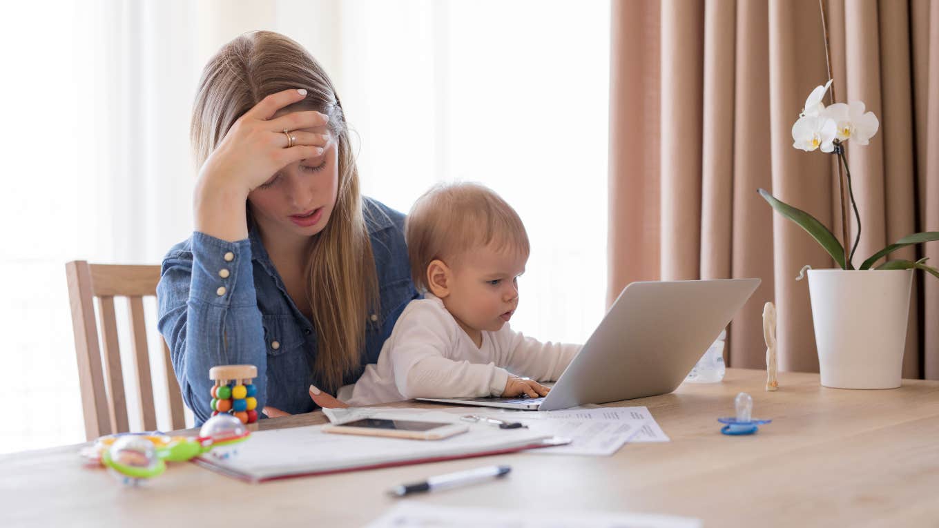 tired mom working with child in her lap