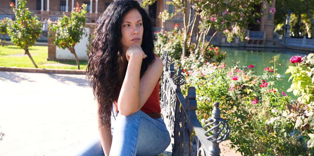 exotic looking woman sitting on bench