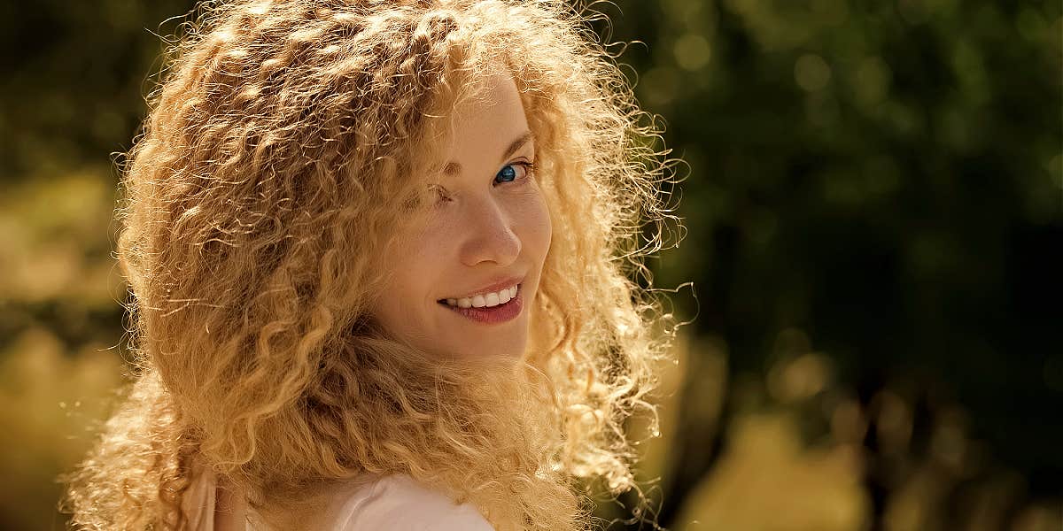 Expand your aura woman glowing with the sun behind her