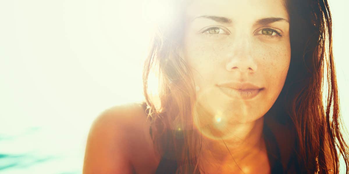 woman backlit by the sun, looking peaceful