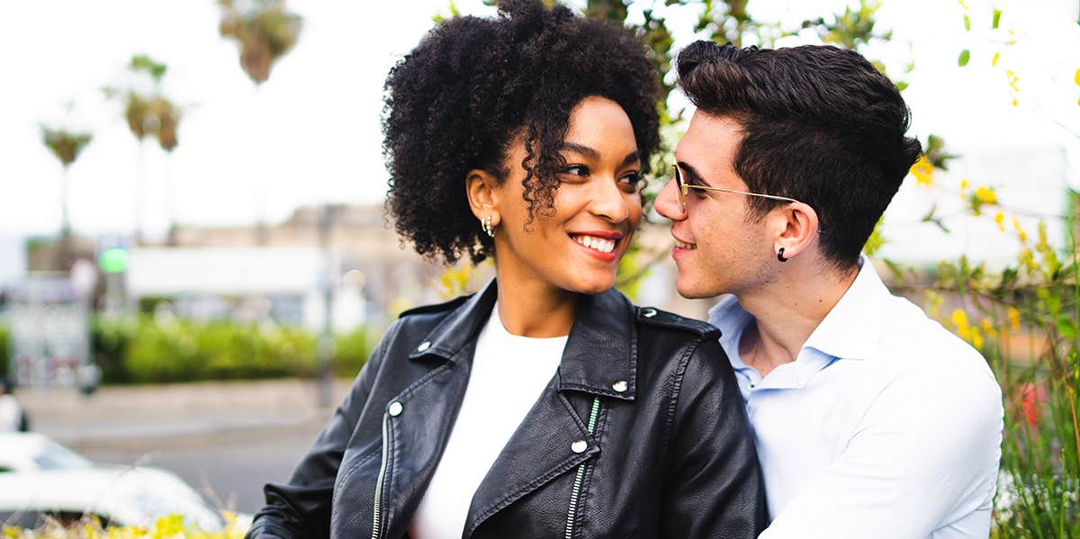 man and woman cuddling and smiling at each other