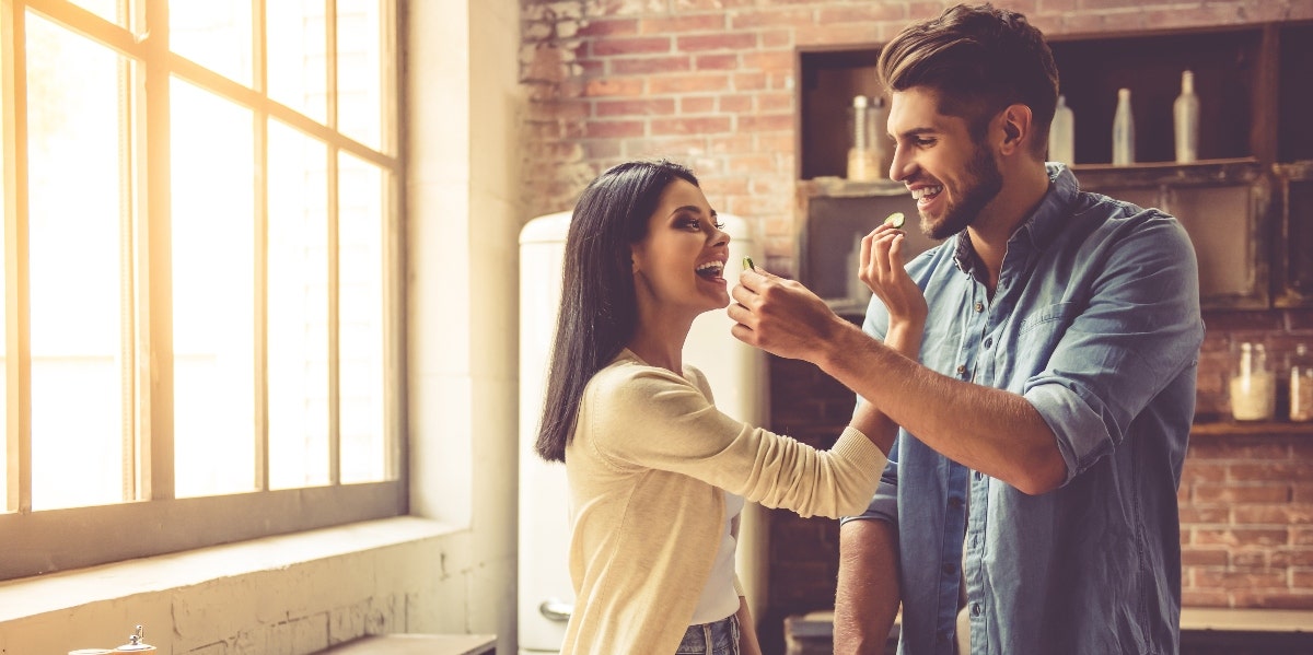 man and woman eating together in kitchen