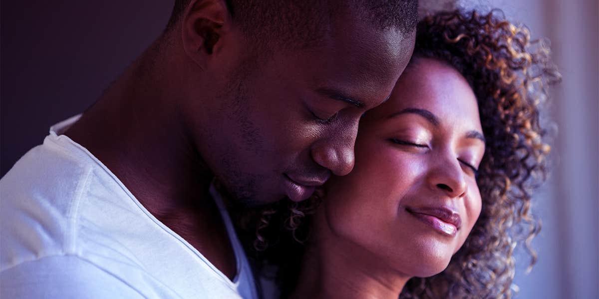 Experts Reveal The 5 Romantic Behaviors That Are Not Given Nearly Enough Credit man hugging woman from behind