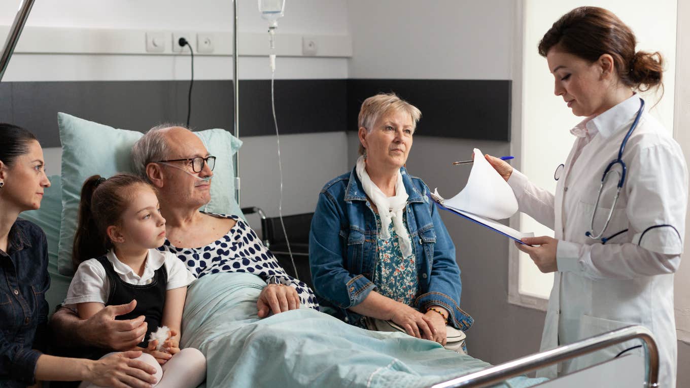 family sitting around man in hospital bed