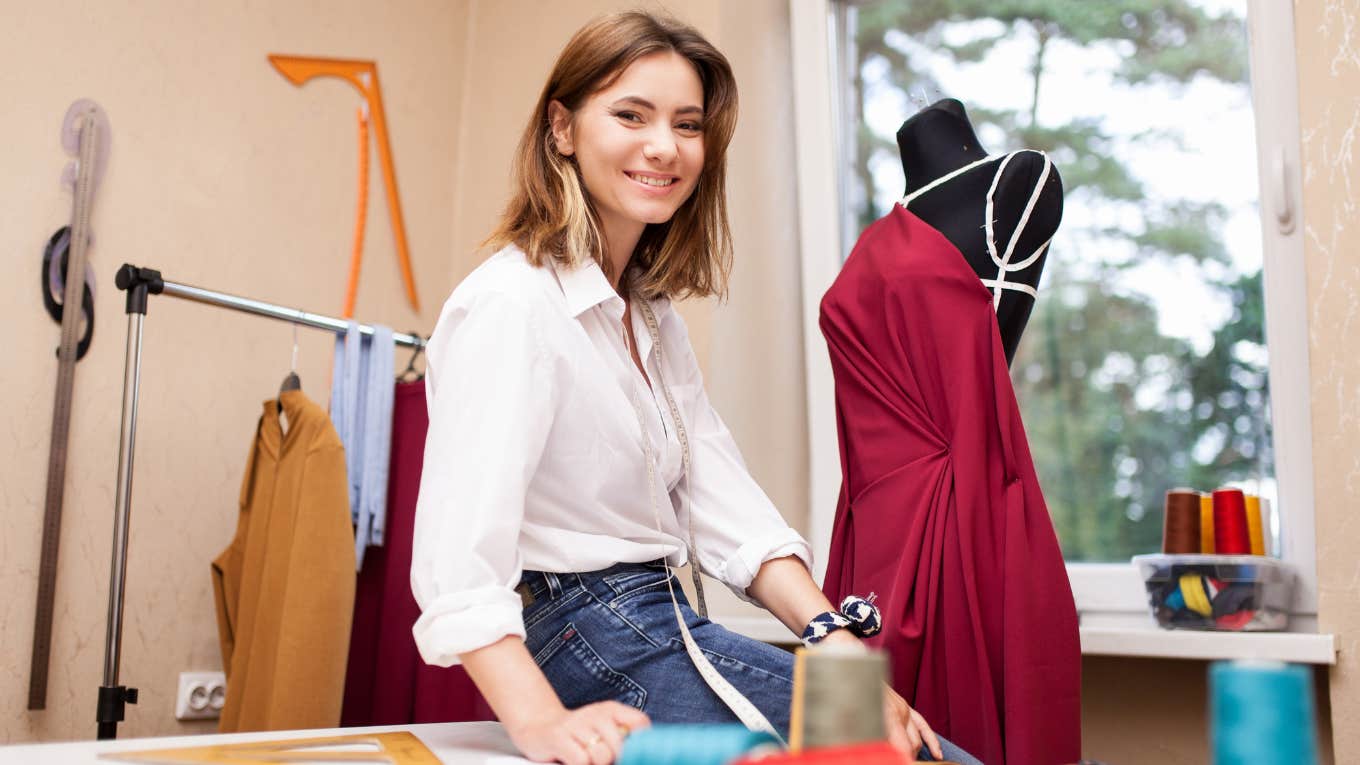 Young fashion designer sitting on a desk. 