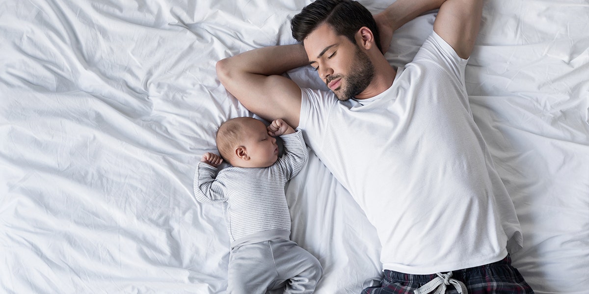 man with baby on bed