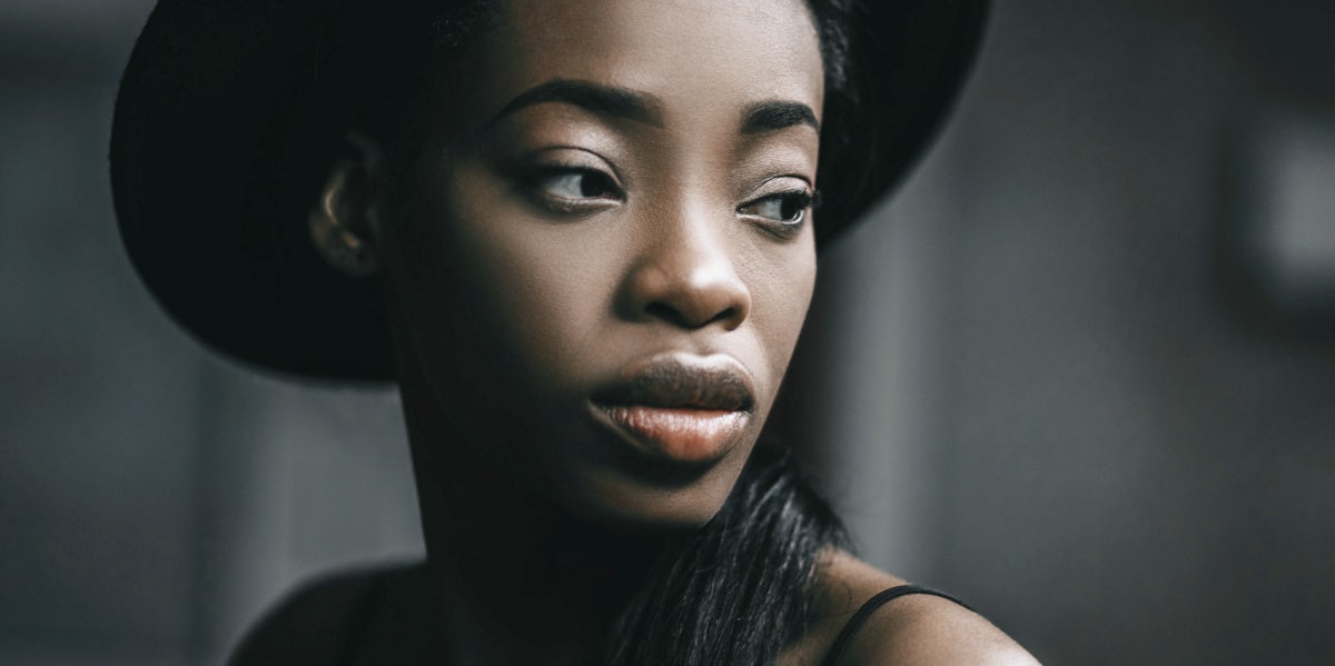 serious woman in black hat staring to the side