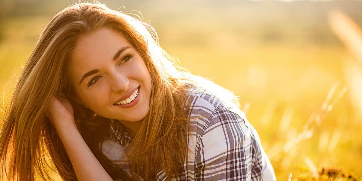 Content woman smiles in wheat field