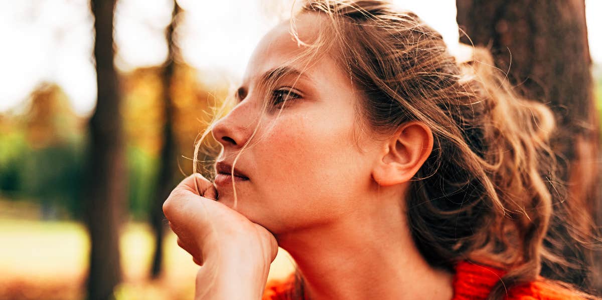 Sad woman outdoors stares into distance