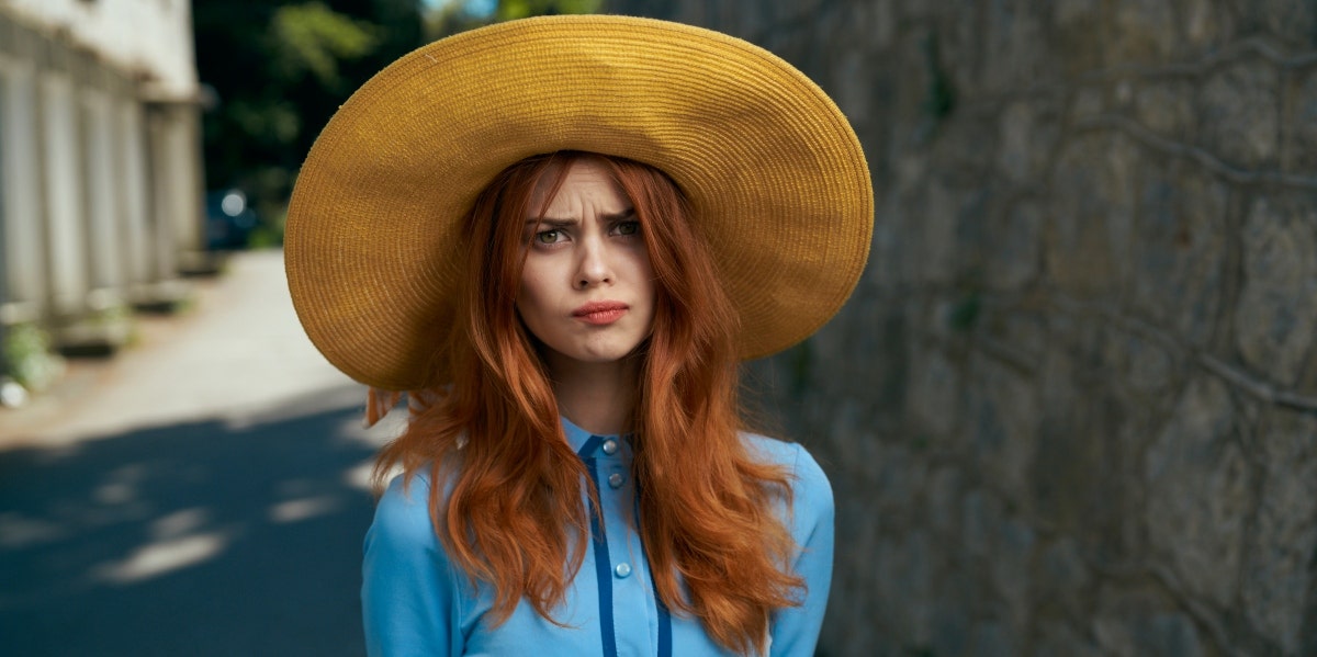 feelings of anger disappointed woman wearing a large hat
