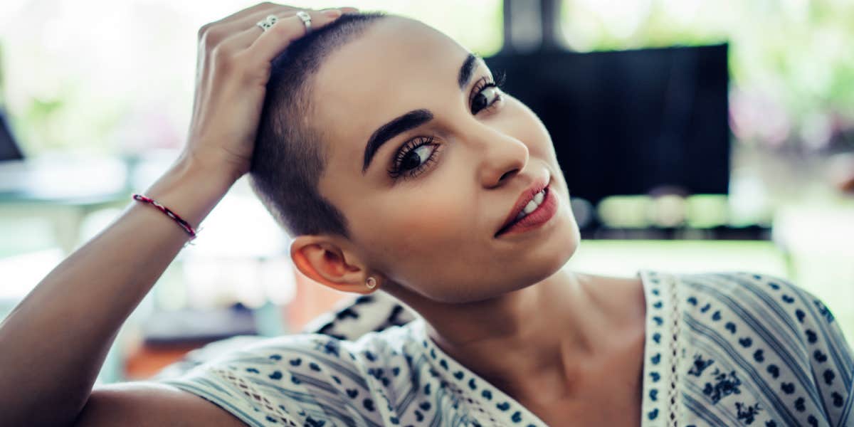confident young woman with a shaved head, looking peaceful 