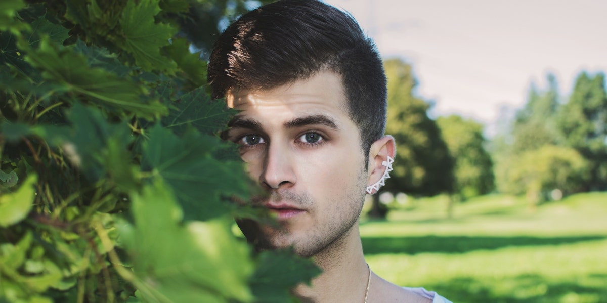 man standing by leaves