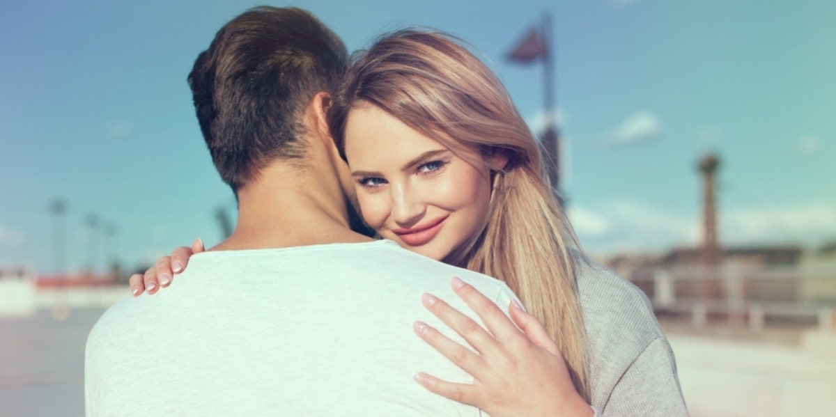 sassy blonde woman hugging man 