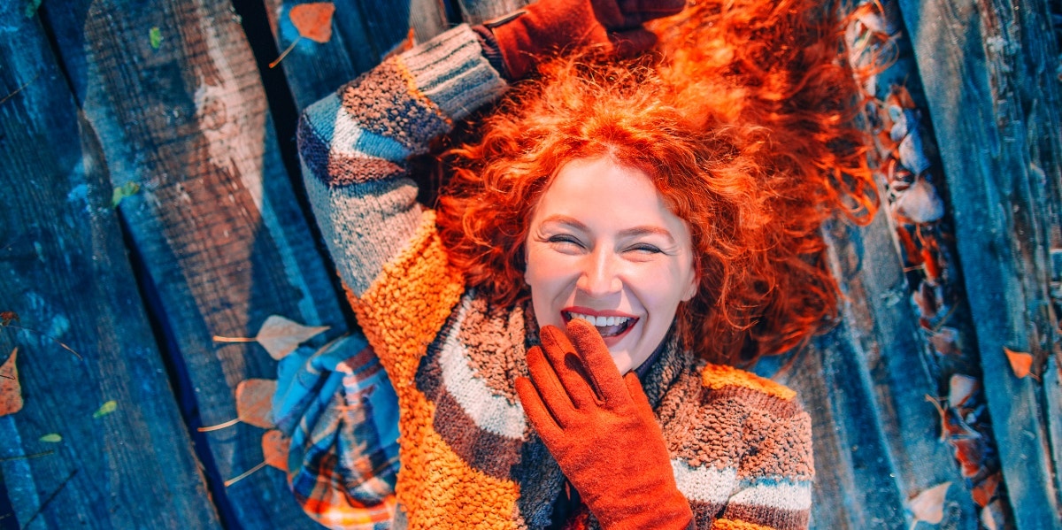 redheaded woman celebrating the first day of fall