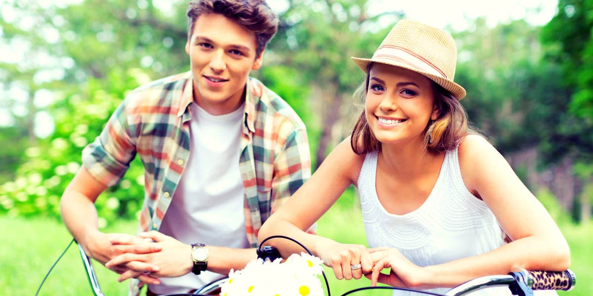 young smiling couple on bicycles who are each other's first loves