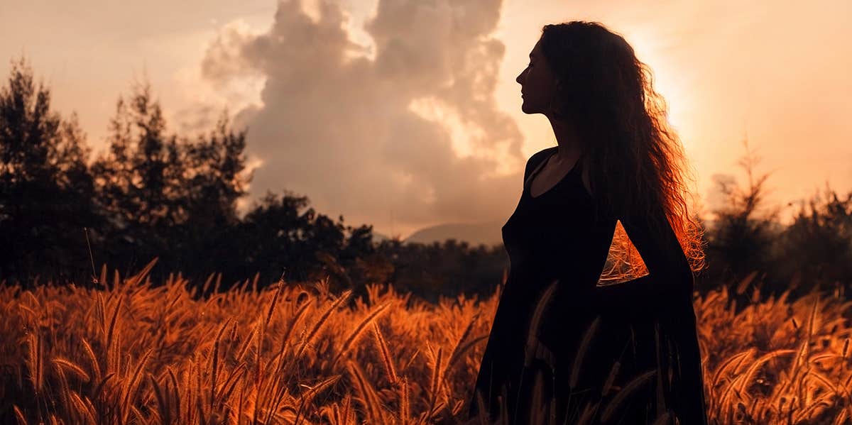 silhouette of girl in dress at sunset in field
