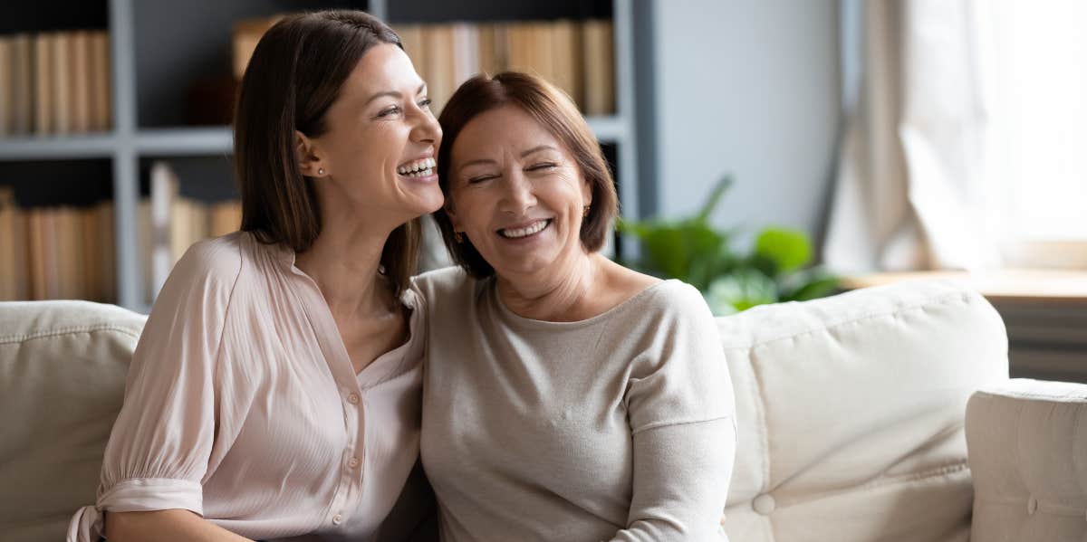 mom and adult daughter laughing together