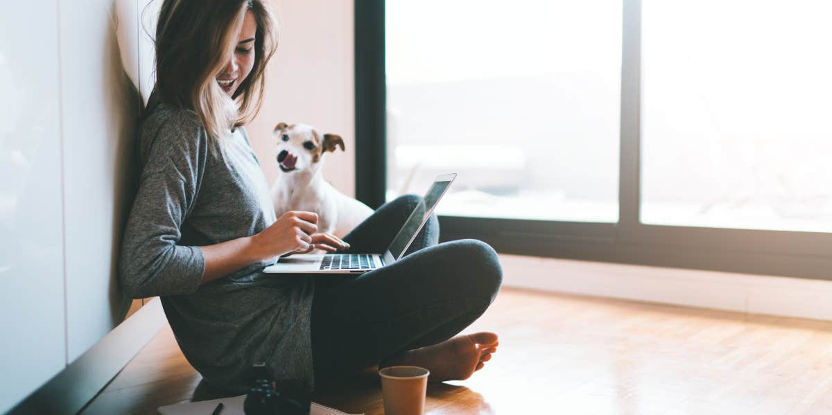 woman on laptop with dog