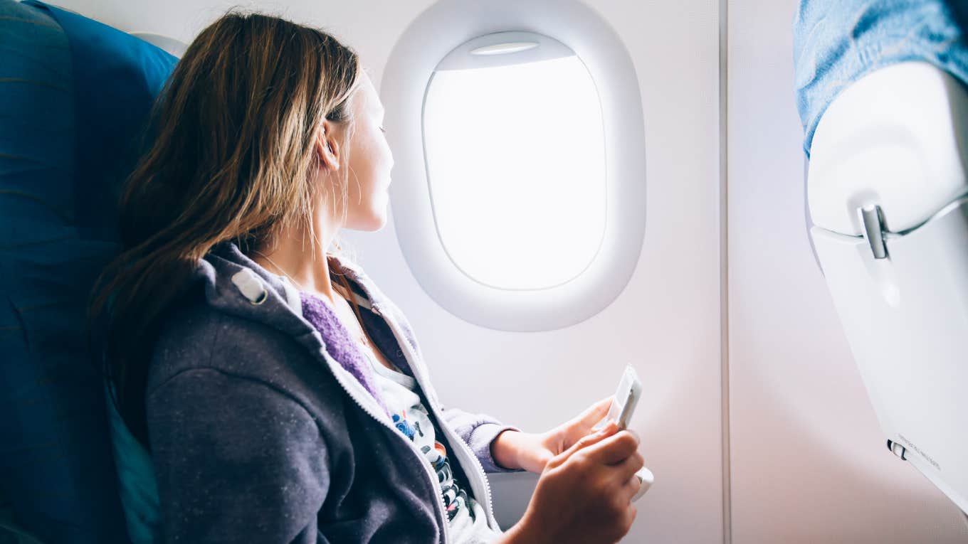 Woman looking out of a plane window. 