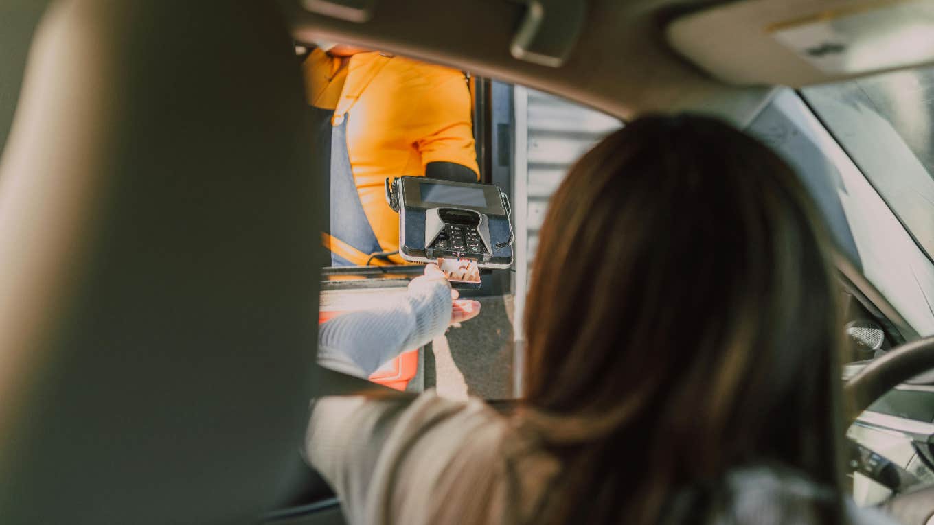 woman paying at drive thru