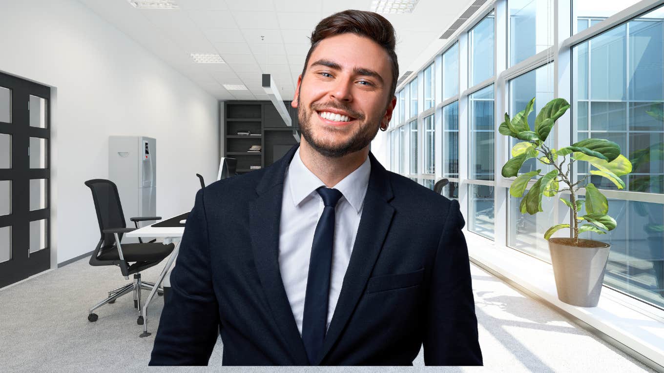 Man in a suit smiling in a corporate office. 