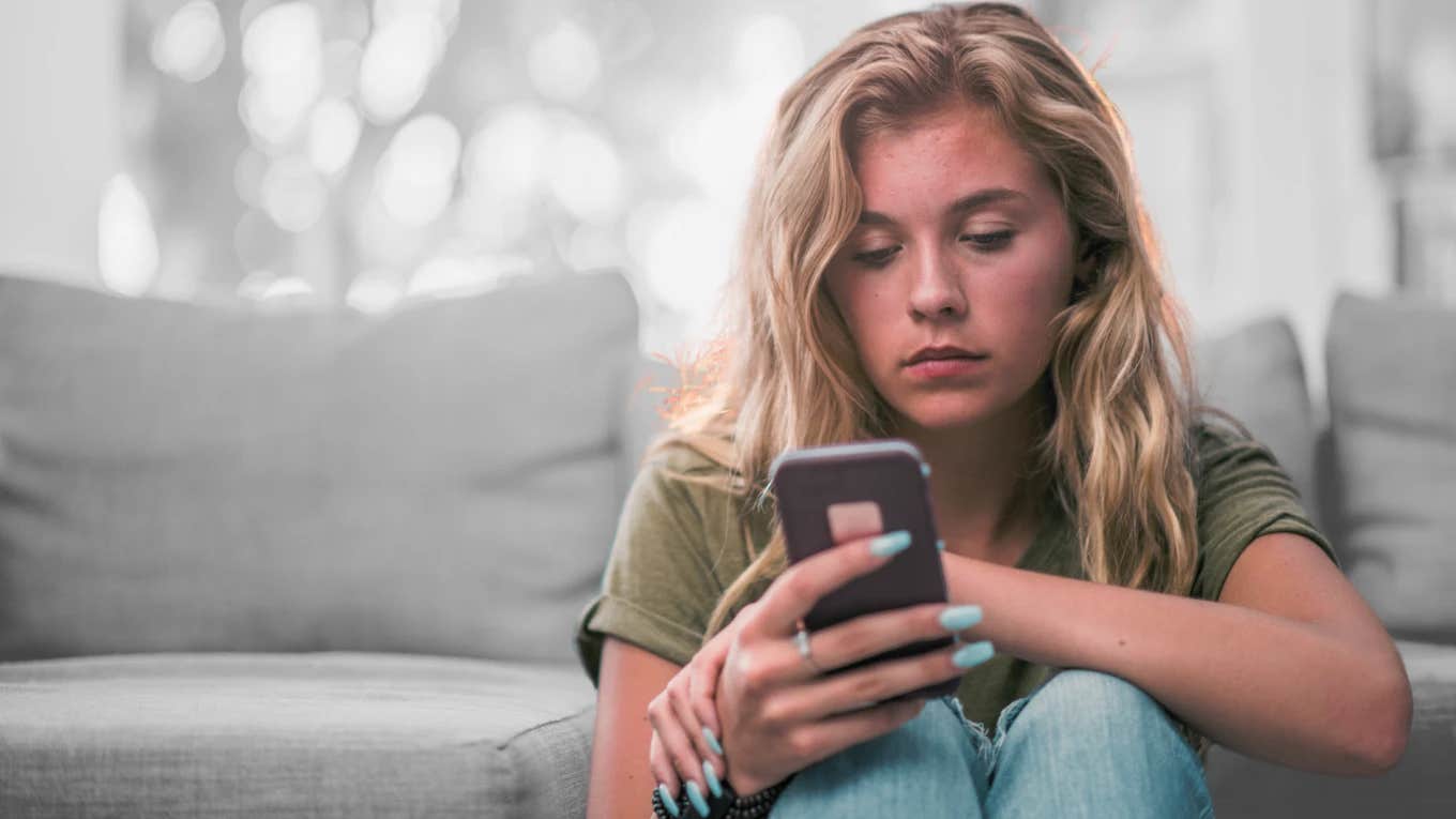 Young American girl looking sadly at her phone