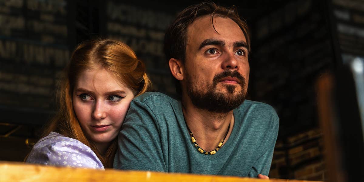 woman hugging man while sitting at table