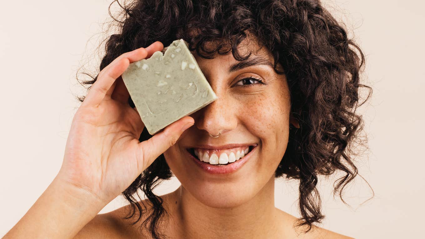 14-Year-Old Invented A Bar Of Soap That Prevents Skin Cancer — And It Only Costs 50 Cents young woman smiling at the camera while holding a bar of natural soap close to her face.