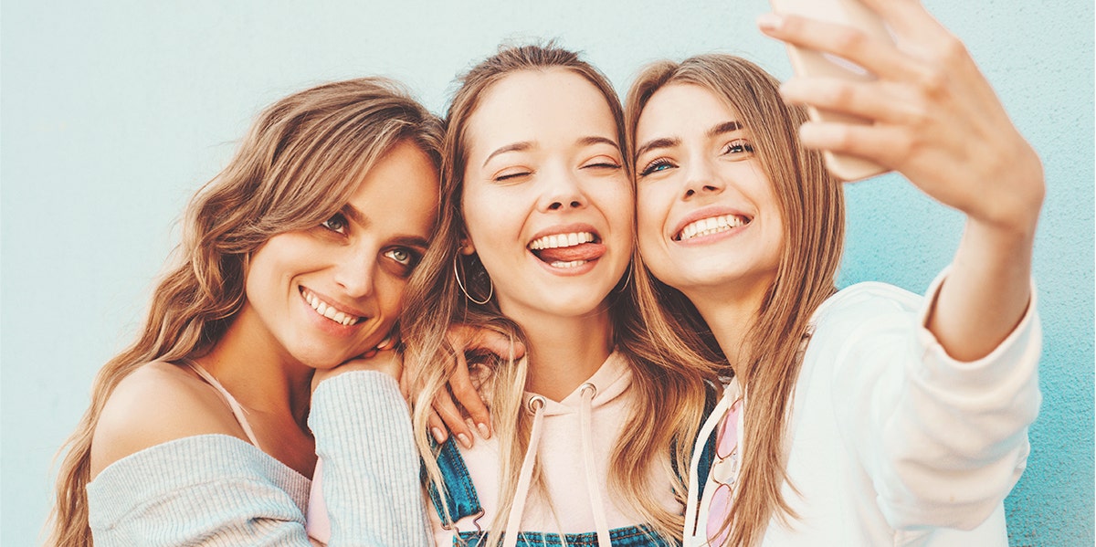 three friends taking selfies