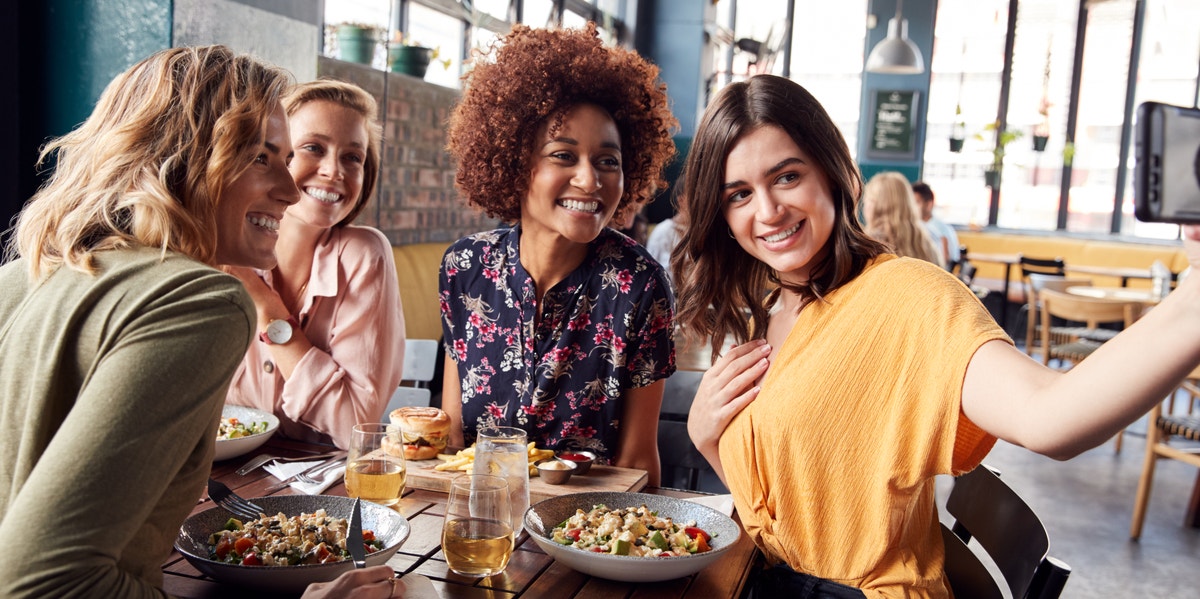 friends eating lunch together taking selfie