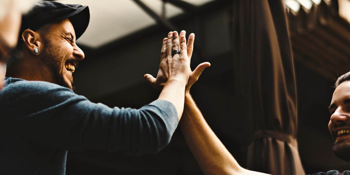 Two men happily high-fiving