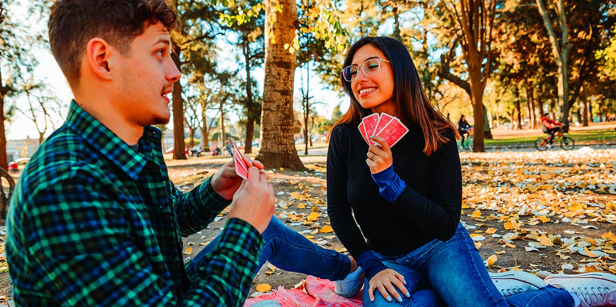 2 people playing cards outside