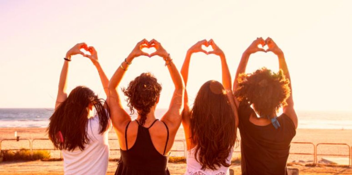 friends next to each other holding hearts