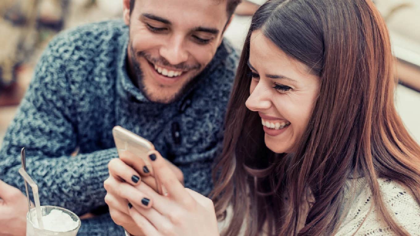 couple laughing playing on phone together