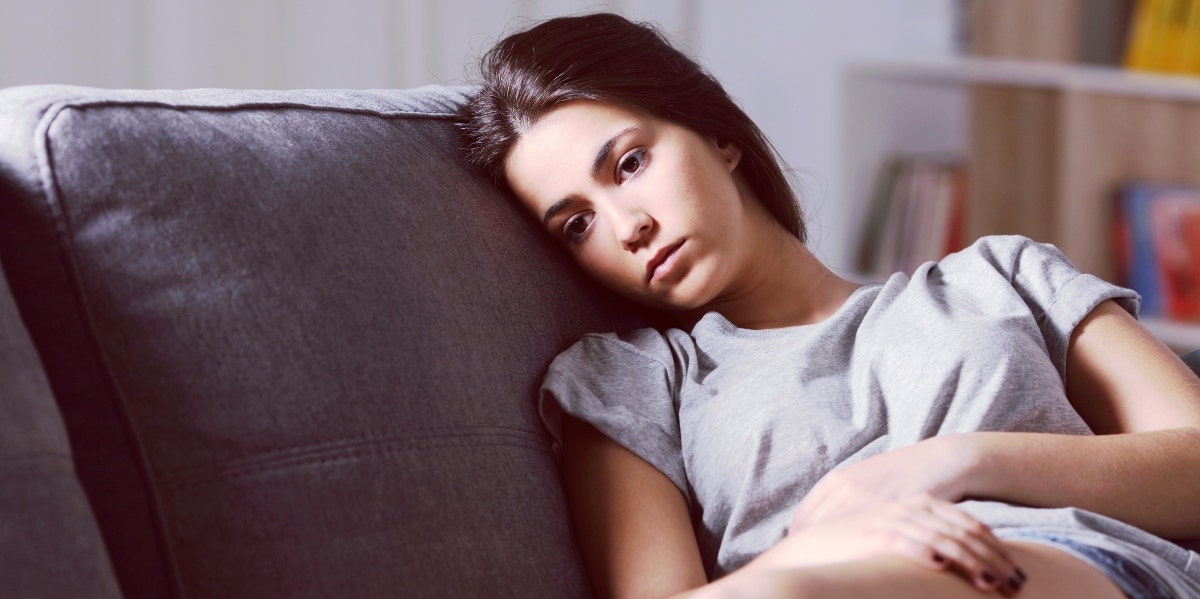 gaslighting sayings sad-looking woman sitting on couch