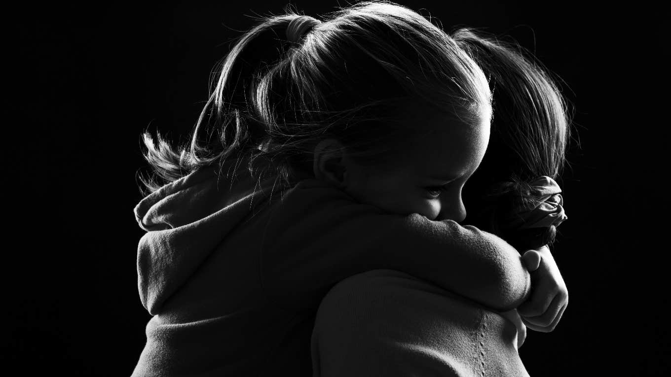 child and woman hugging black and white