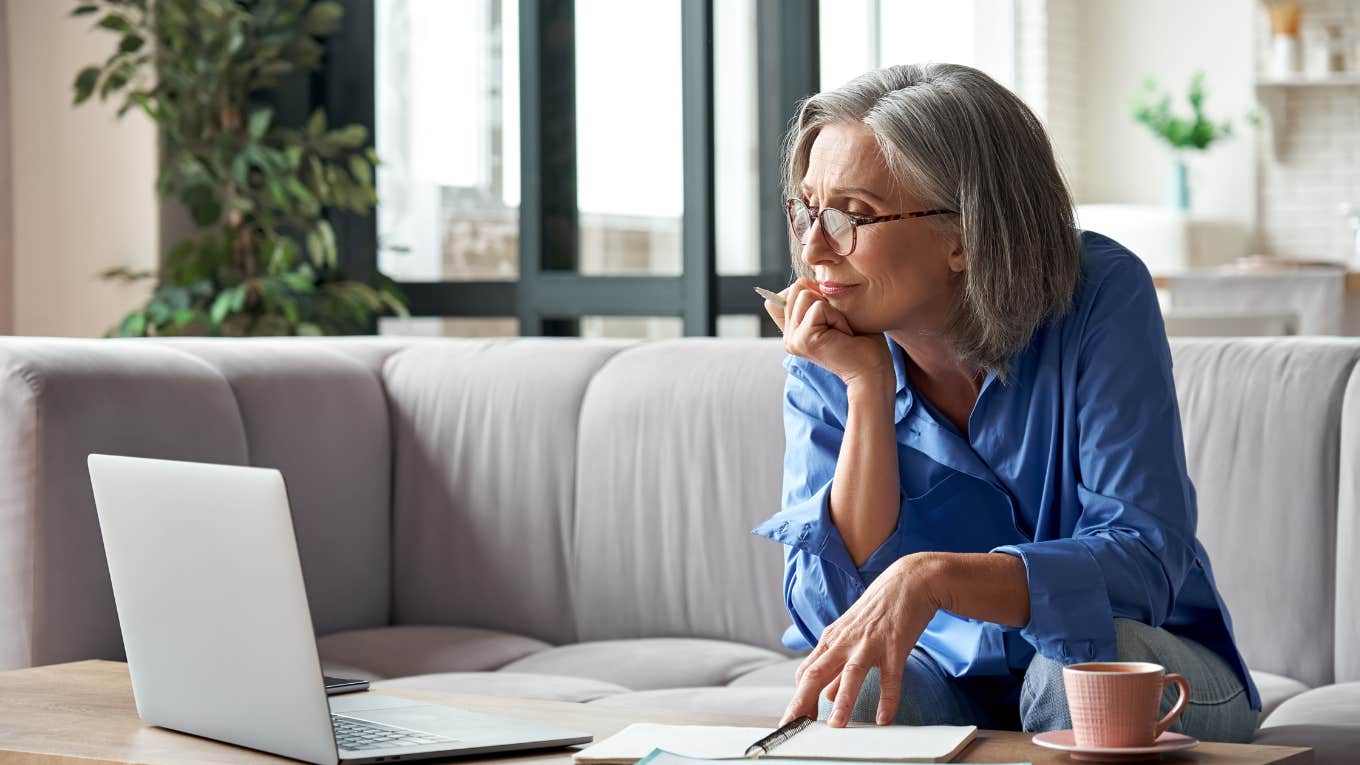 older woman watching laptop while sitting at table