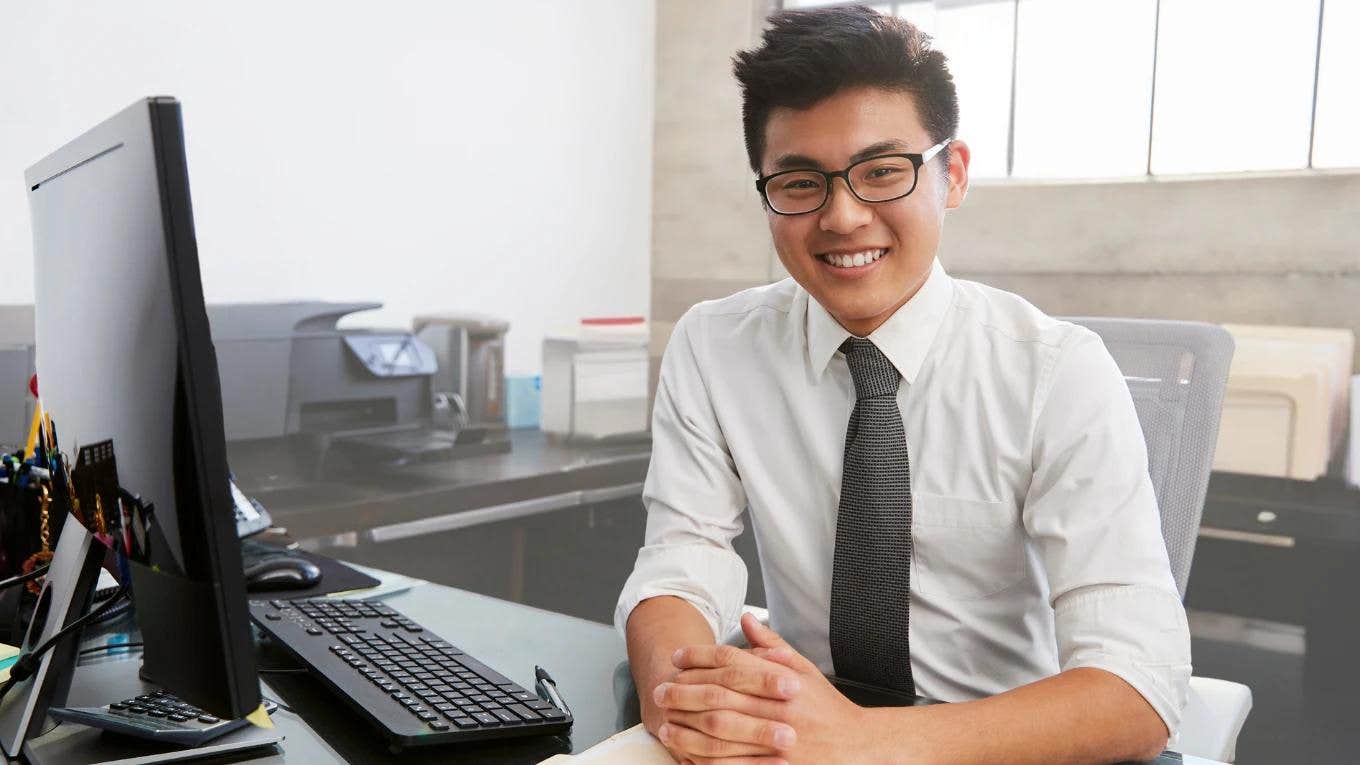 Gen Z worker smiling at desk