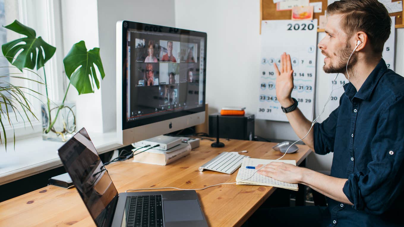 man having Zoom video conferencing call via computer while sitting at desk