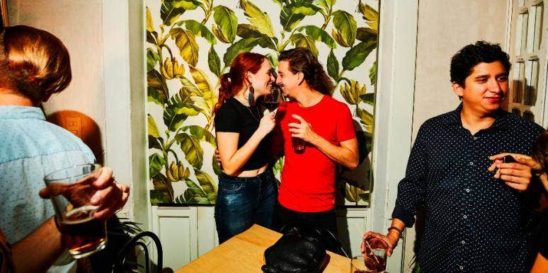 Get Flirty! 14 Body Language Dos & Don'ts To Show A Guy You're Into Him flirty couple at a party kissing