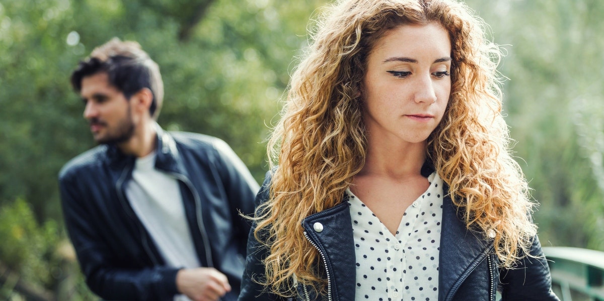 sad looking woman with man behind her